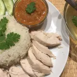 Khao man gai: Reis, Hähnchen, Gurkenscheiben, scharfe Sauce und eine klare Brühe mit Ei und Koriander.