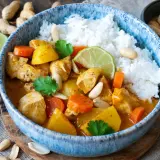 Hähnchen-Massaman-Curry mit Reis, Karotten, Kartoffeln, Erdnüssen und Koriander.