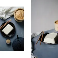 Ein Block Seidentofu auf einem Teller, daneben Stäbchen, eine Teekanne und Sesam. Was ist Seidentofu? Zart und cremig, ideal für asiatische Gerichte.