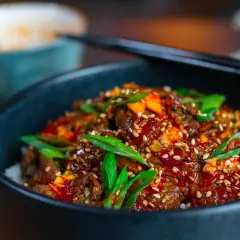 Schüssel mit Reis und würzigem Rindfleisch, garniert mit Frühlingszwiebeln und Sesam. Eine köstliche bulgogi sauce alternative.