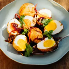 Scharf angebratene Eier, garniert mit Koriander und Chili, serviert mit einer dunklen Sauce. Ein Gericht, das selbst den Schwiegersohn beeindrucken würde.
