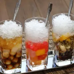 Drei Gläser mit zerstoßenem Eis und bunten Zutaten, ein erfrischendes che vietnam.