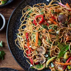 Ein köstliches asia nudeln gericht mit viel Gemüse und Pilzen, garniert mit Chiliflocken.