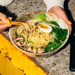 Eine Schüssel mit einer köstlichen japanischen Nudelsorte, garniert mit Pilzen, Ei und Pak Choi.