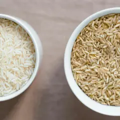 Zwei Schalen mit Reis: links weißer Basmati oder Jasmin Reis, rechts brauner Reis.