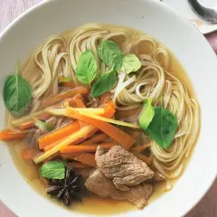 Herzhafte nudelsuppe mit zarten Rindfleischstreifen, Karotten, frischem Basilikum und Sternanis.