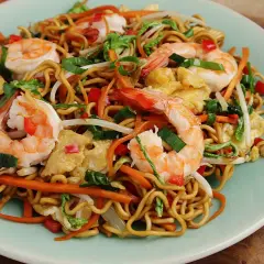 Mi Quang: Nudeln mit Garnelen, Karotten, Ei und Frühlingszwiebeln auf einem Teller.