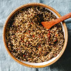 Schüssel mit selbstgemachtem Furikake, einer Mischung aus Sesam, Algen und Chili. Ein Holzspatel liegt darin.