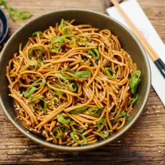 Schüssel mit Soba Nudeln, garniert mit Frühlingszwiebeln und Sesam. Ein einfaches Soba Nudeln Rezept für jeden Tag.