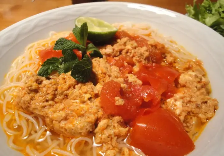 Bun rieu: Nudelsuppe mit Hackfleisch, Tomaten, Minze und Limette. Ein herzhaftes Gericht, das zum Genießen einlädt.