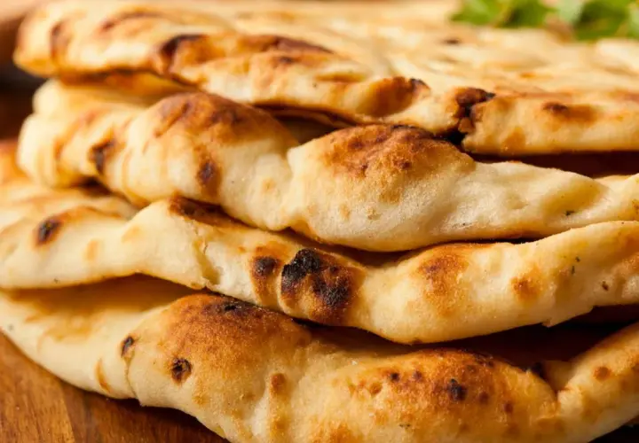 Gestapeltes, goldbraunes Naan-Brot mit leicht verbrannten Stellen. Dieses Fladenbrot ist ein Grundnahrungsmittel der indischen Küche.