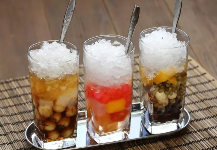 Drei Gläser mit zerstoßenem Eis und bunten Zutaten, ein erfrischendes che vietnam.
