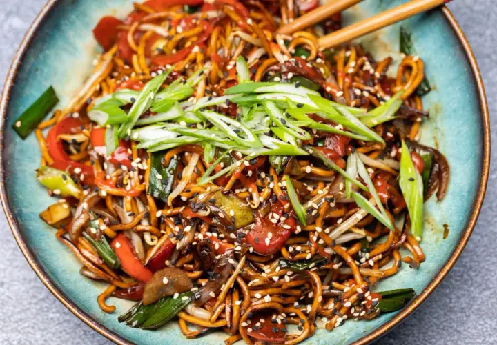 Chao mian Nudeln mit Gemüse, garniert mit Frühlingszwiebeln und Sesam.