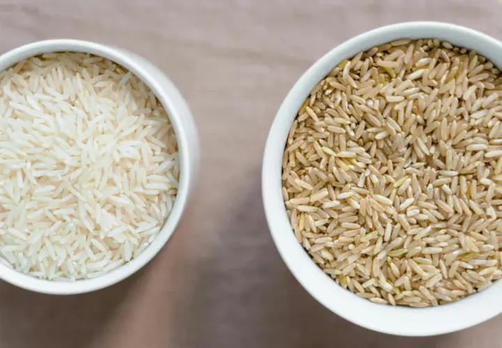 Zwei Schalen mit Reis: links weißer Basmati oder Jasmin Reis, rechts brauner Reis.