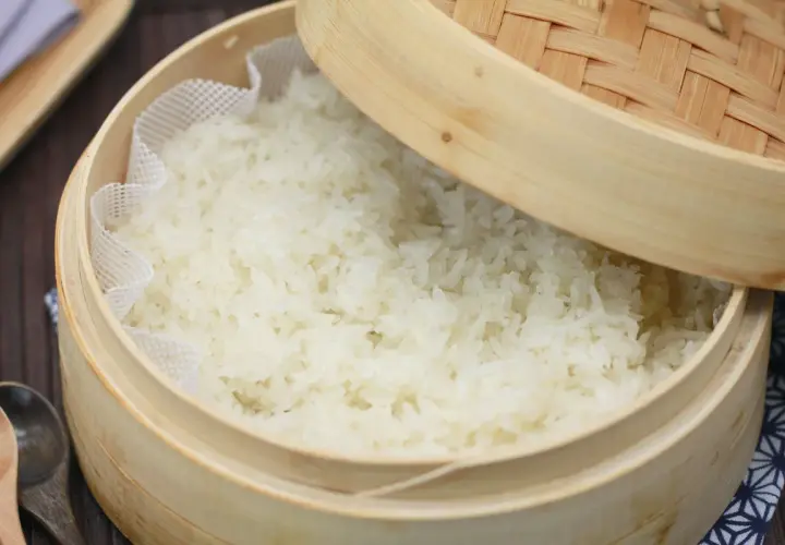 Frisch gedämpfter Klebreis kochen in einem Bambuskorb. Perfekt für asiatische Gerichte.
