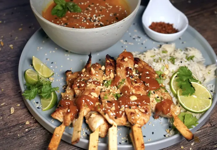 Saftige sate spiesse mit Erdnusssauce, Reis, Limettenspalten und Koriander. Ein Fest für die Sinne!