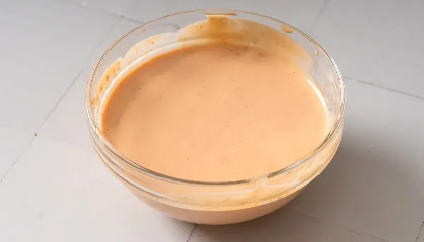 Eine Schüssel mit cremiger, leicht orangefarbener chinesischer Mayo, bereit zum Dippen.
