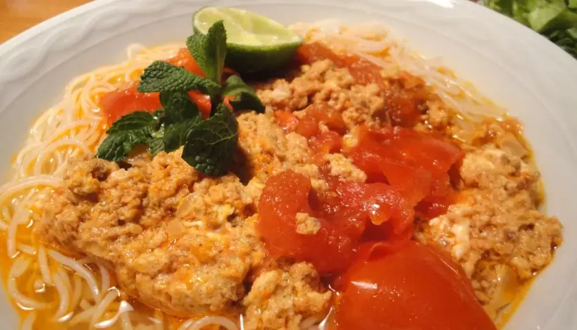 Bun rieu: Nudelsuppe mit Hackfleisch, Tomaten, Minze und Limette. Ein herzhaftes Gericht, das zum Genießen einlädt.