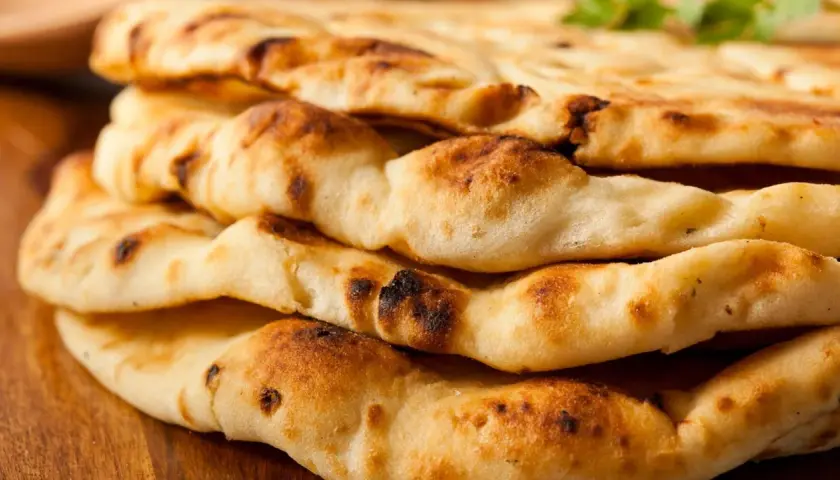 Gestapeltes, goldbraunes Naan-Brot mit leicht verbrannten Stellen. Dieses Fladenbrot ist ein Grundnahrungsmittel der indischen Küche.