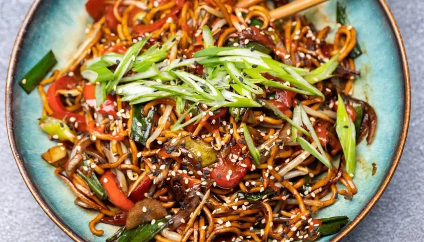 Chao mian Nudeln mit Gemüse, garniert mit Frühlingszwiebeln und Sesam.