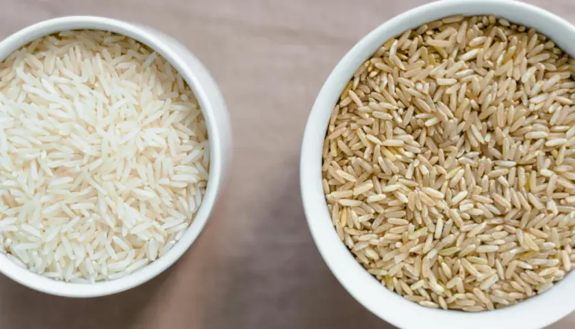 Zwei Schalen mit Reis: links weißer Basmati oder Jasmin Reis, rechts brauner Reis.