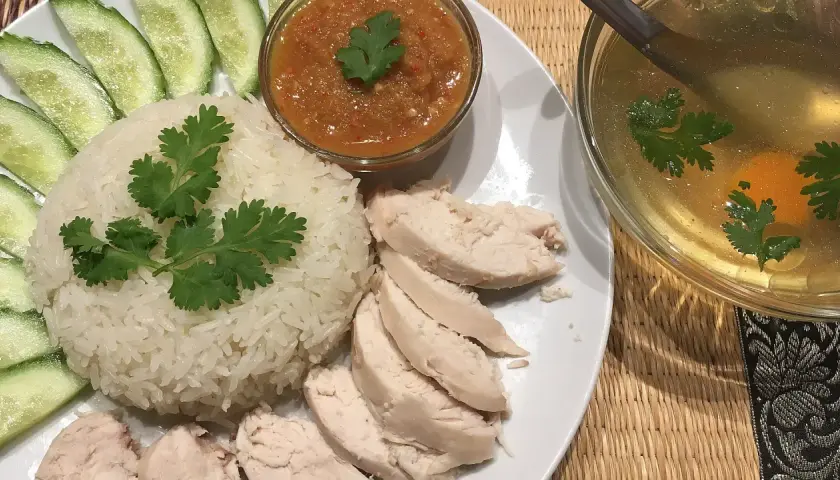 Khao man gai: Reis, Hähnchen, Gurkenscheiben, scharfe Sauce und eine klare Brühe mit Ei und Koriander.