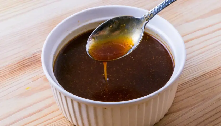 Eine Löffelprobe der dunklen Yakisoba-Sauce, die die Zutaten für ein köstliches Gericht andeutet.