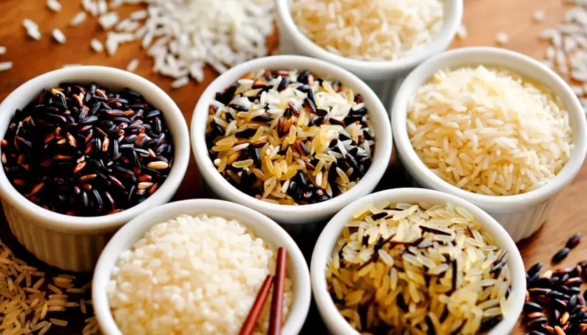 Verschiedene Reissorten in Schalen: schwarzer Reis, Basmati und eine Mischung. Ist Reis gesund? Ja, diese Vielfalt zeigt, wie gesund Reis sein kann.