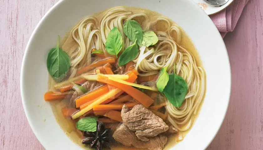 Herzhafte nudelsuppe mit zarten Rindfleischstreifen, Karotten, frischem Basilikum und Sternanis.