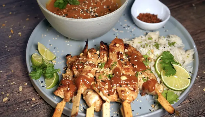 Saftige sate spiesse mit Erdnusssauce, Reis, Limettenspalten und Koriander. Ein Fest für die Sinne!