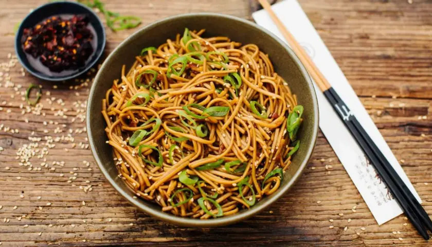 Schüssel mit Soba Nudeln, garniert mit Frühlingszwiebeln und Sesam. Ein einfaches Soba Nudeln Rezept für jeden Tag.