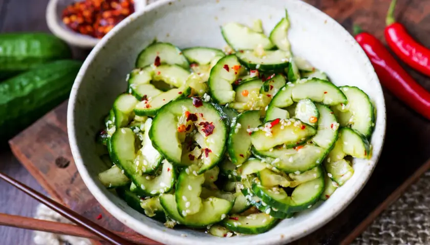 Frischer, asiatischer Gurkensalat in Spiralen, garniert mit Sesam und Chili-Flocken. Ein leichter Genuss.
