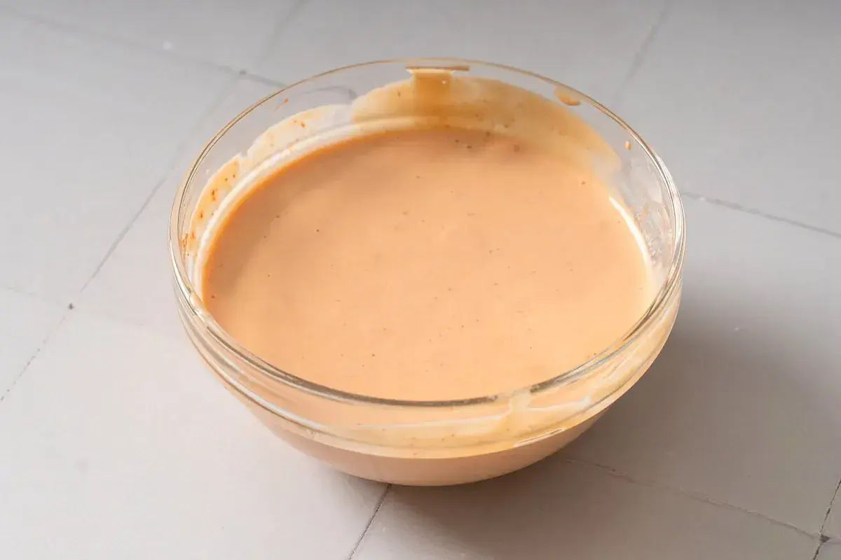 Eine Schüssel mit cremiger, leicht orangefarbener chinesischer Mayo, bereit zum Dippen.