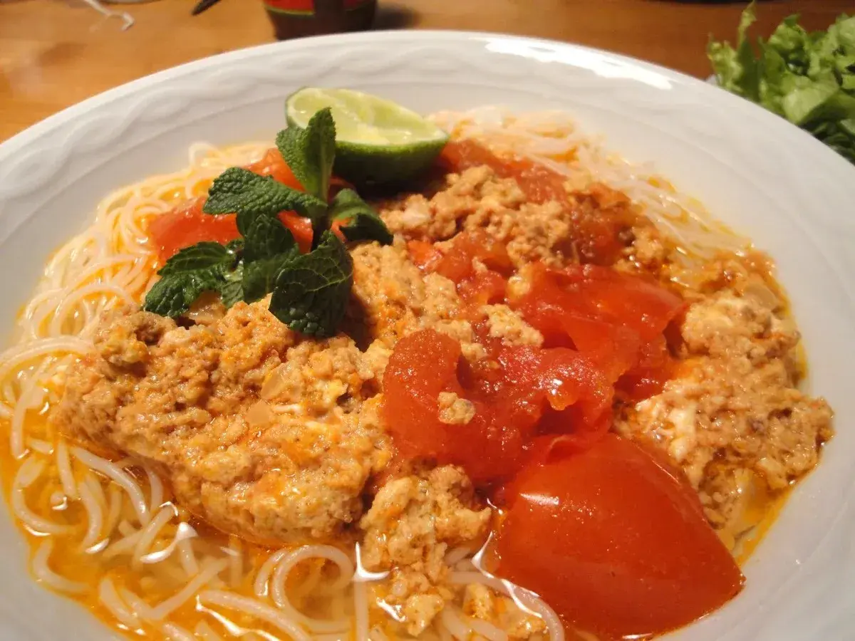 Bun rieu: Nudelsuppe mit Hackfleisch, Tomaten, Minze und Limette. Ein herzhaftes Gericht, das zum Genießen einlädt.