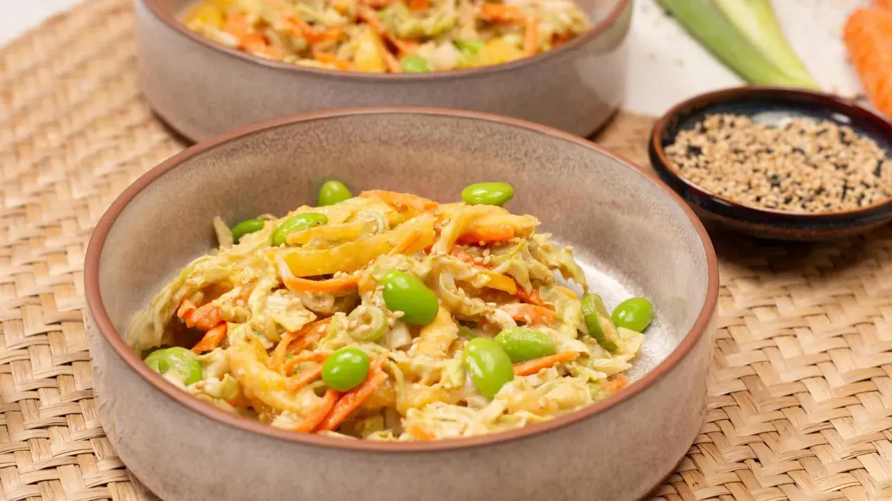 Frischer Chinakohlsalat asiatisch mit Edamame, Karottenstreifen und Sesam in einer Schüssel.