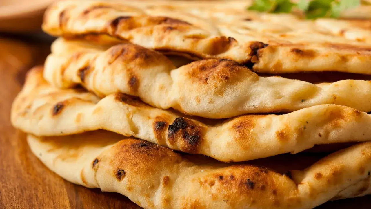 Gestapeltes, goldbraunes Naan-Brot mit leicht verbrannten Stellen. Dieses Fladenbrot ist ein Grundnahrungsmittel der indischen Küche.