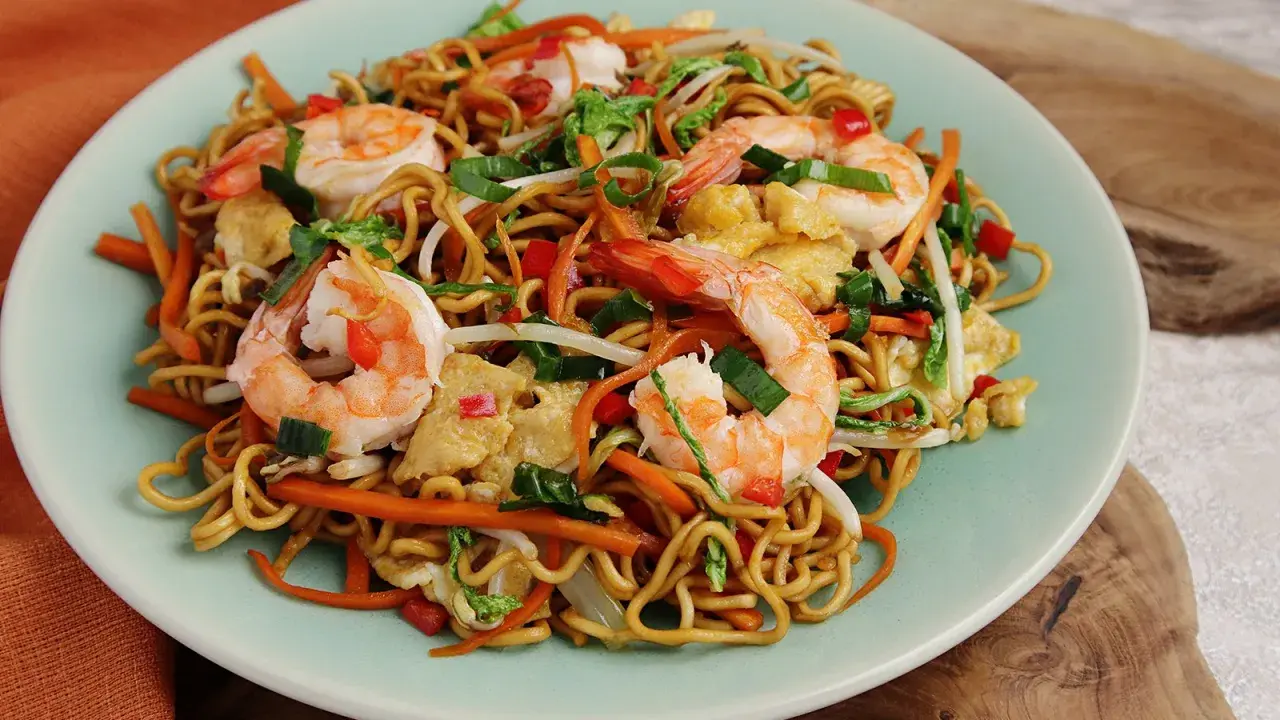 Mi Quang: Nudeln mit Garnelen, Karotten, Ei und Frühlingszwiebeln auf einem Teller.