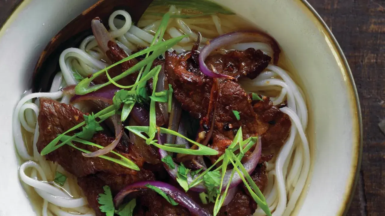 Herzhaftes Pho Kho mit zarten Rindfleischstreifen, Reisnudeln, roten Zwiebeln und Frühlingszwiebeln in einer aromatischen Brühe.