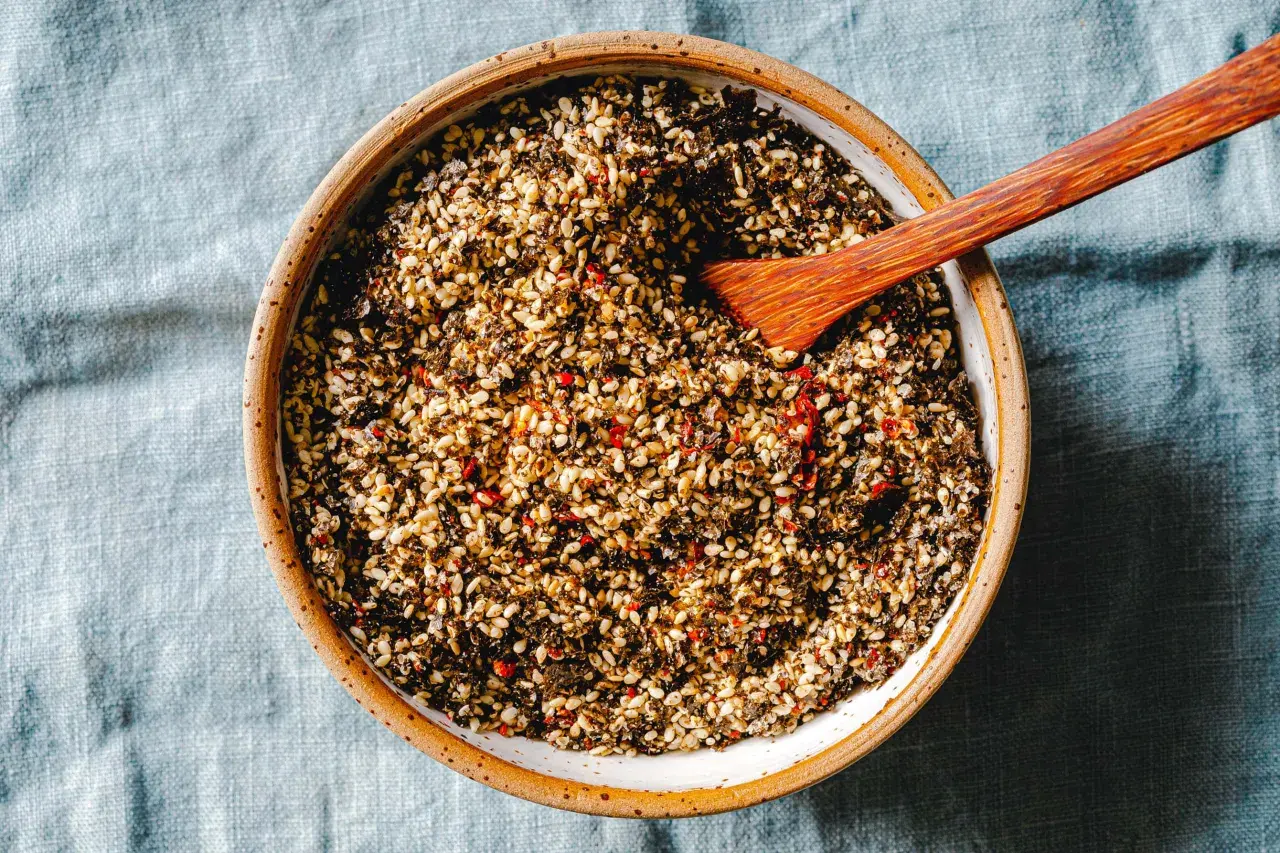 Schüssel mit selbstgemachtem Furikake, einer Mischung aus Sesam, Algen und Chili. Ein Holzspatel liegt darin.