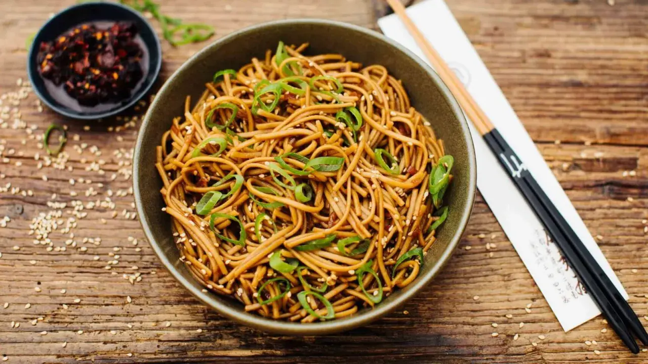 Schüssel mit Soba Nudeln, garniert mit Frühlingszwiebeln und Sesam. Ein einfaches Soba Nudeln Rezept für jeden Tag.