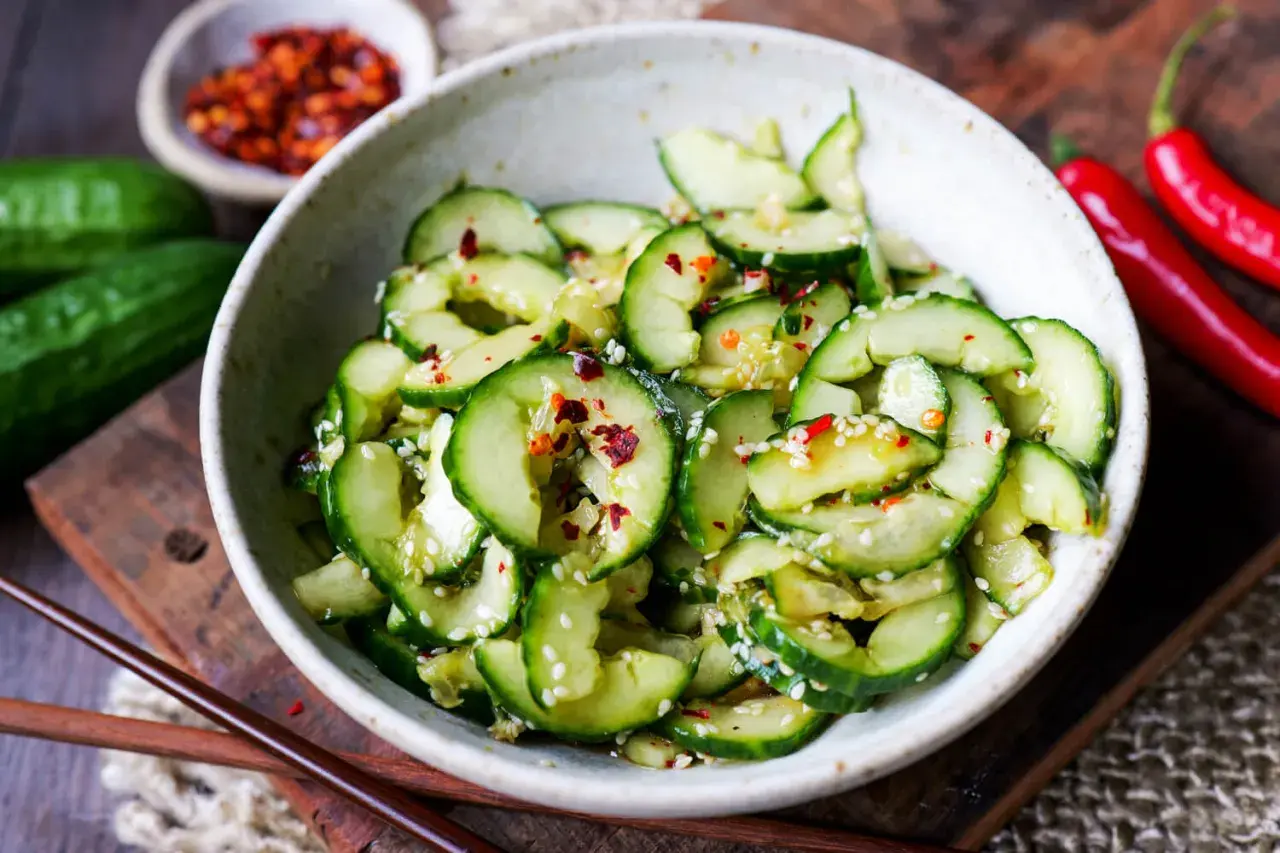 Frischer, asiatischer Gurkensalat in Spiralen, garniert mit Sesam und Chili-Flocken. Ein leichter Genuss.