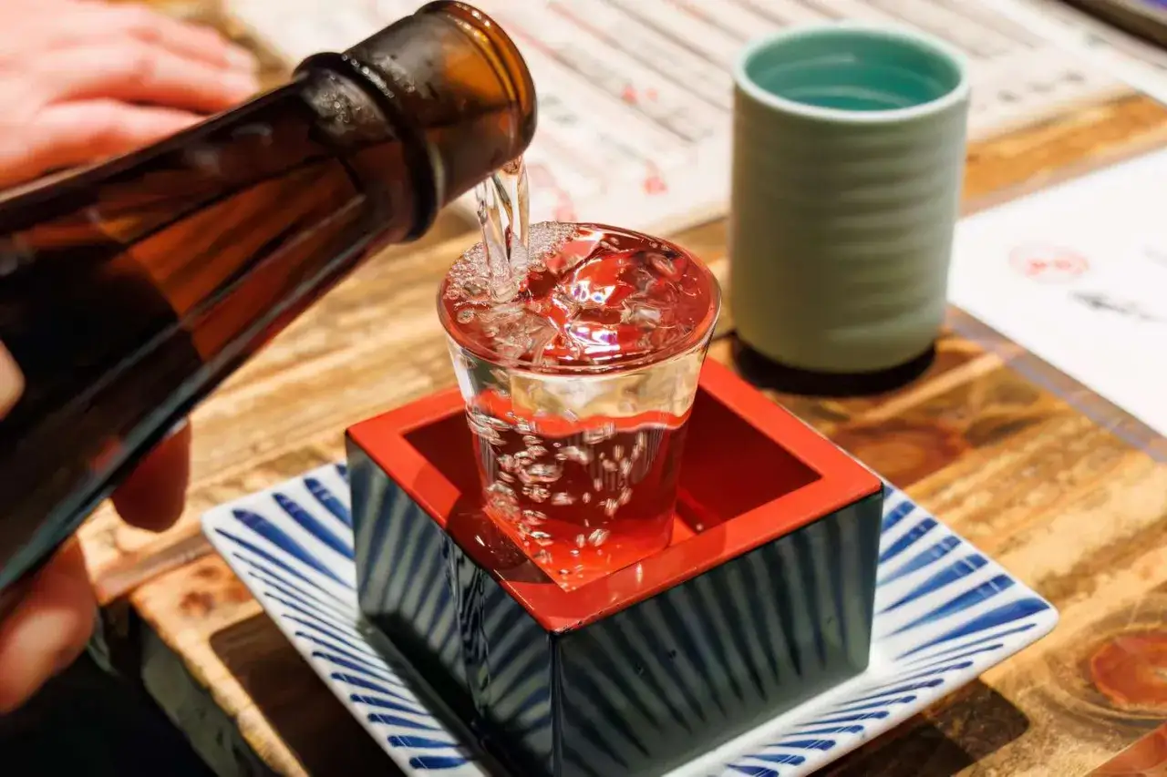 Sake wird in ein Glas gegossen, bereit für den Genuss des einzigartigen sake geschmack.