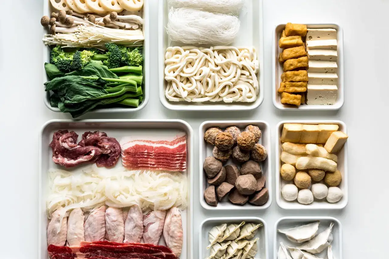 Zutaten f&uuml;r Hot Pot: Gem&uuml;se, Pilze, Nudeln, Tofu, Fleisch, Fischb&auml;llchen und Teigtaschen.