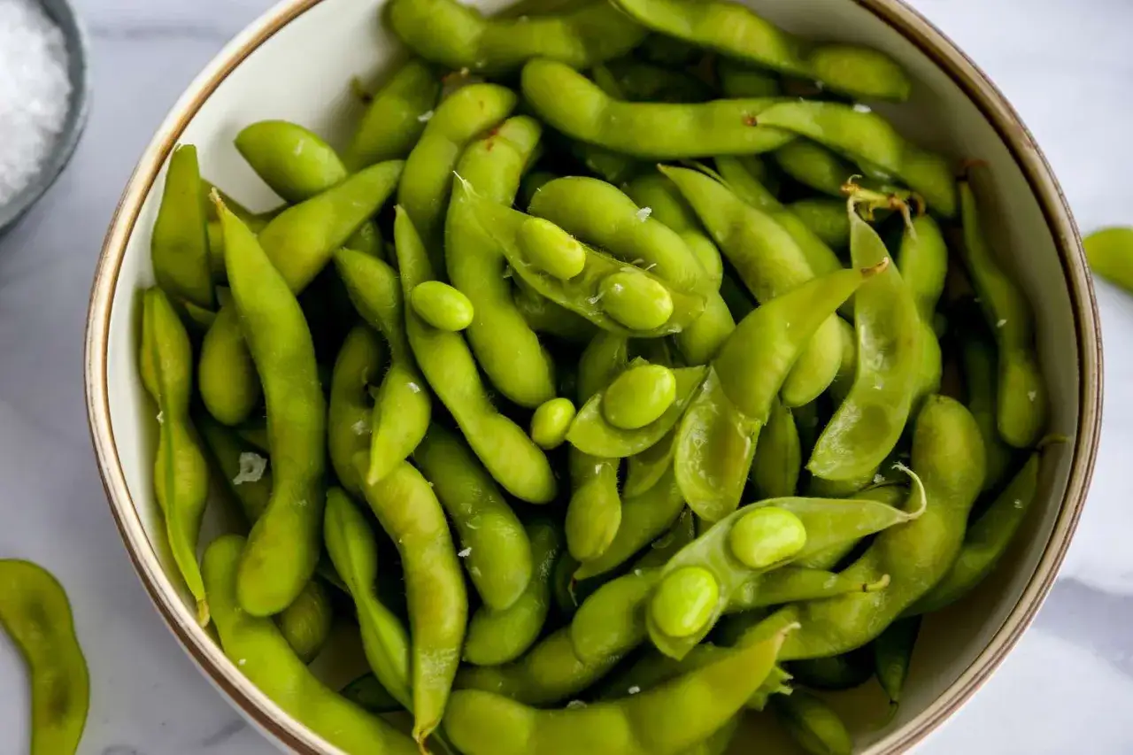 Eine Sch&uuml;ssel mit frisch zubereitetem Edamame, bestreut mit grobem Salz. Perfekt zum Snacken oder als Beilage.