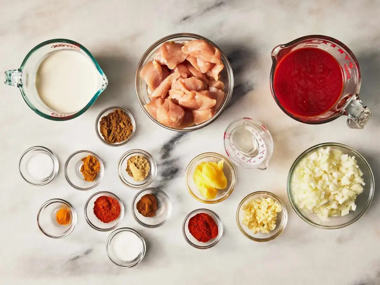 Zutaten f&uuml;r eine k&ouml;stliche Masala-Sauce: H&auml;hnchen, Tomaten, Zwiebeln, Knoblauch, Ingwer, Gew&uuml;rze und Sahne.