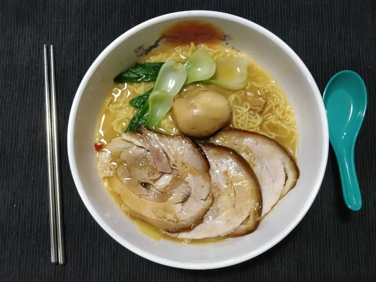Schüssel mit Ramen-Nudeln, Chashu-Schweinefleisch, Ei und Bok Choy in einer herzhaften Brühe, perfekt zubereitet mit Shio Tare.