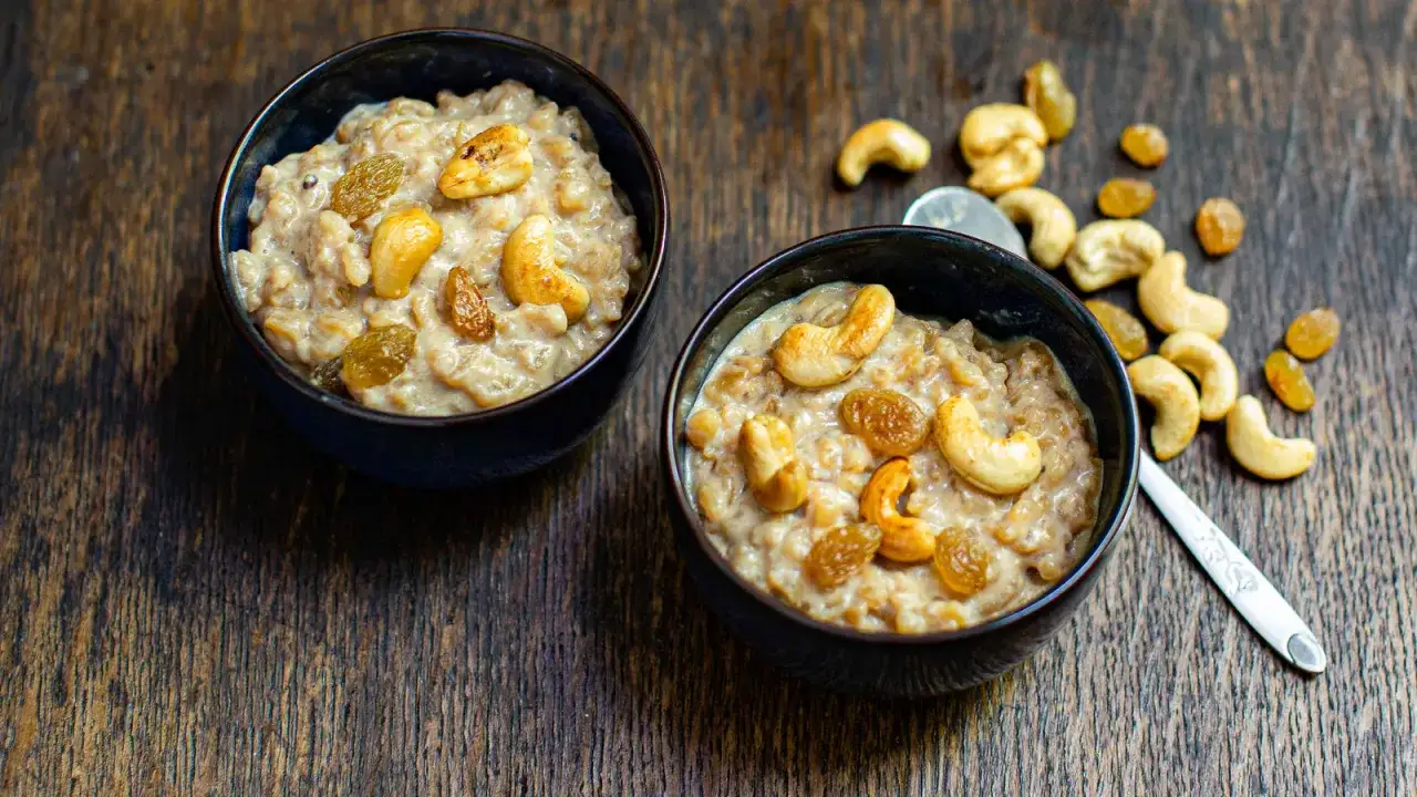 Zwei Schalen cremigen Congee mit Cashewkernen und Rosinen. Ein köstliches Congee Rezept für jeden Tag.