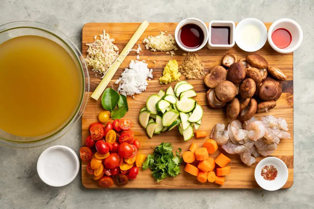 Zutaten f&uuml;r Tom Jam: Garnelen, Pilze, Zucchini, Tomaten, Karotten, Koriander, Ingwer, Knoblauch, Zitronengras, Limettenbl&auml;tter, Br&uuml;he, Sojasauce, Kokosmilch.