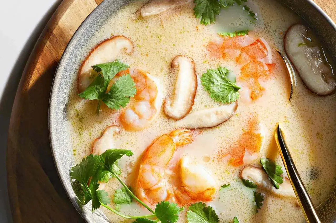 Eine Sch&uuml;ssel cremiges Tom Kha Gung mit Garnelen, Pilzen und Koriander.