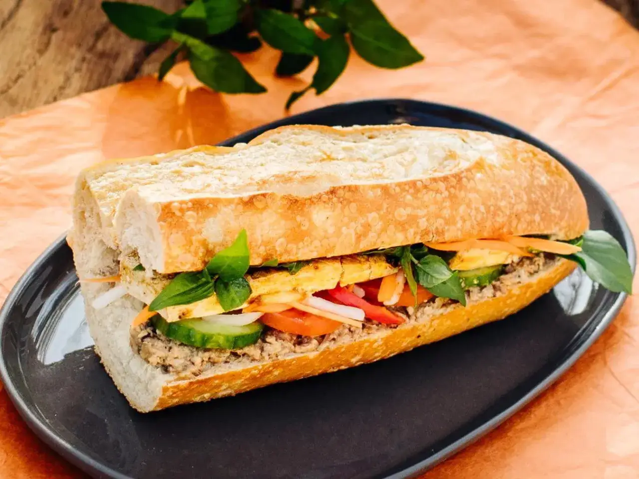 Ein Banh Mi Sandwich mit frischem Baguette, Fleisch, Gurken, Karotten, Tomaten und Kräutern. Ein leckeres Banh Mi Rezept zum Nachmachen.